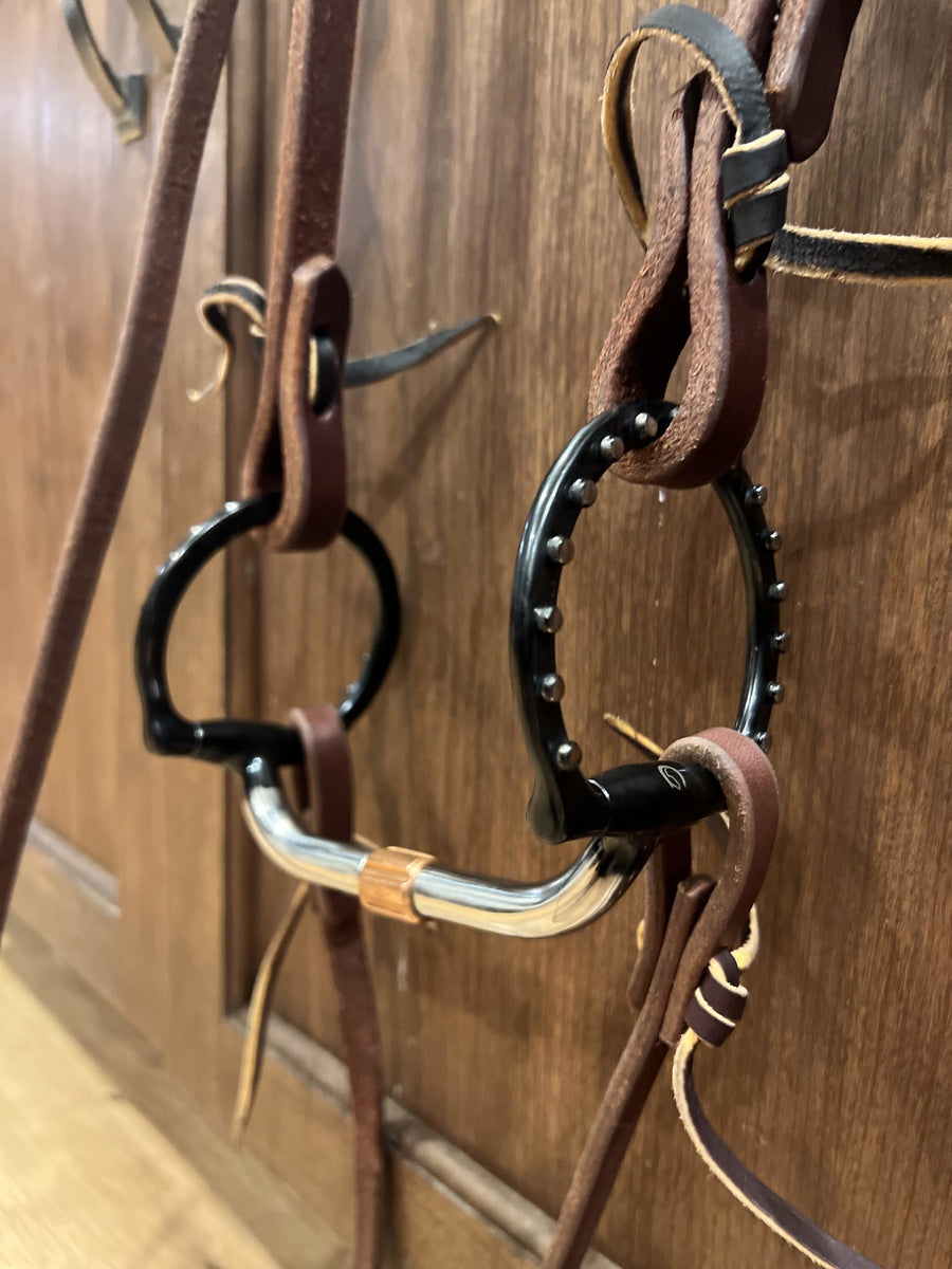 Cavalon D-Ring Pivot Cricket Roller Silver Dotted Snaffle hanging on a leather bridle
